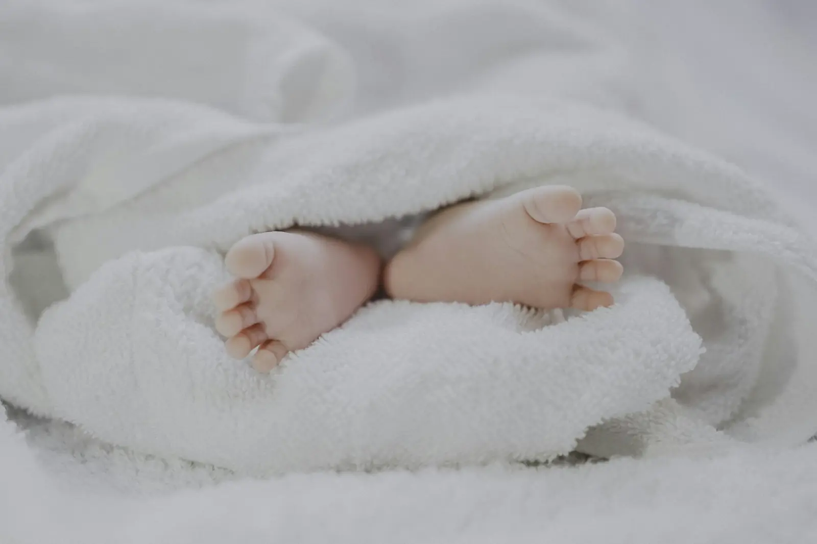 Newborn baby’s feet wrapped in a soft blanket