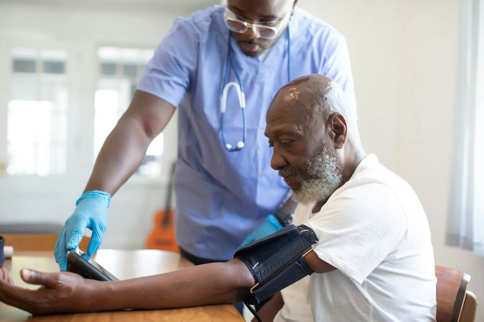 A nurse checking an older patient’s blood pressure
